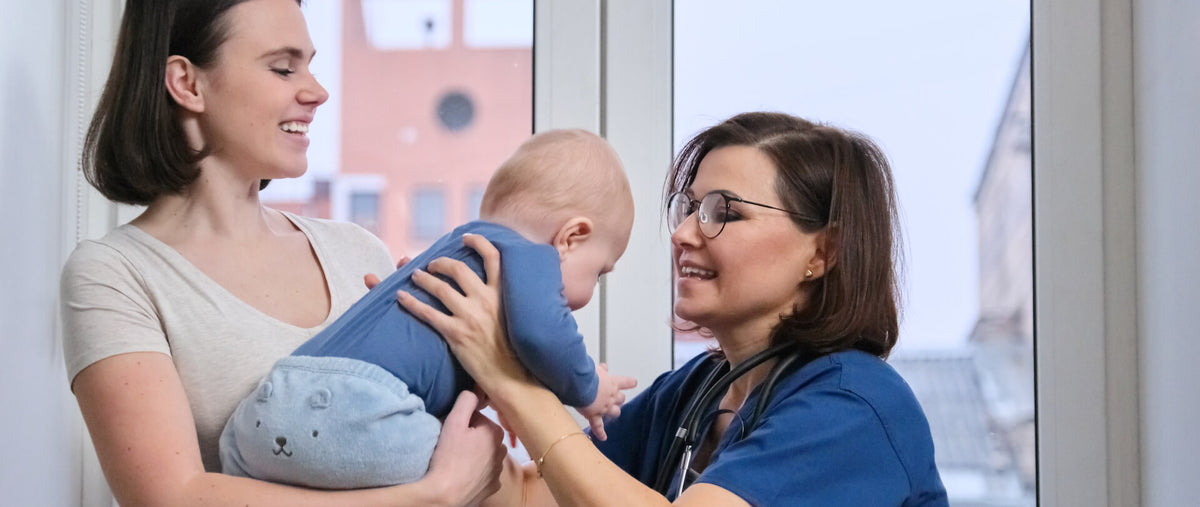 Early evaluation stimulations - Pediatric healthcare professional assessing a baby's early development while the mother provides support during the evaluation.